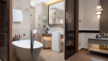 Un bagno moderno con una vasca freestanding, un mobile lavabo con specchio e un portasciugamani.