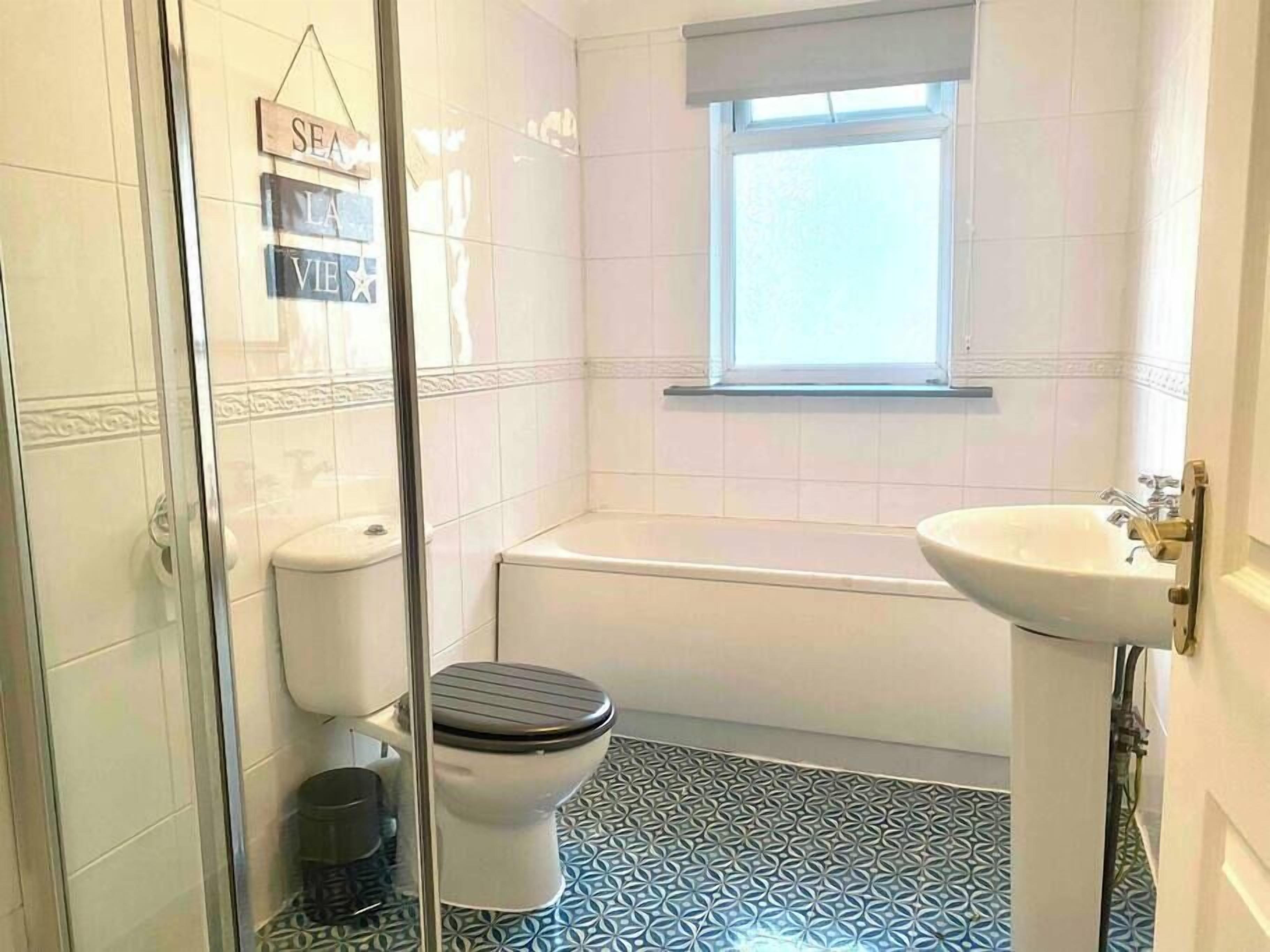 A bathroom with a toilet, a bathtub, and a sink.