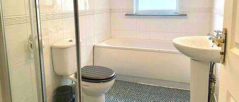 A bathroom with a toilet, a bathtub, and a sink.