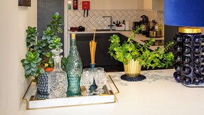 Une cuisine moderne dotée d’un plan de travail en marbre, d’un vase bleu et d’un plateau décoratif contenant de la verrerie.