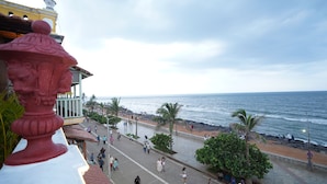 A coastal promenade with a view of the sea, a statue, and a building with balconies. - La Plage SeaView Suites (Puducherry)