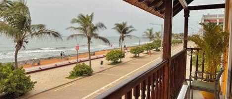 A balcony with a view of the beach and ocean.