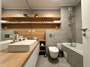 Features a large sink, separate shower area, and storage shelves.