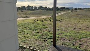 A view from a balcony with a wooden structure and a hanging light fixture. - Ramblers Croft- WiFi, Pet friendly outside (Robe)