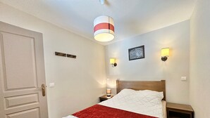 Ein ordentlich eingerichtetes Schlafzimmer mit Bett, Nachttischen und Wandlampen.