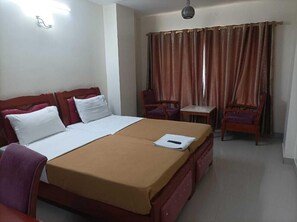 A hotel room with a bed, a desk, and a chair. - Shri Valli Resdiency (Chennai)