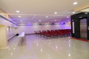 A conference room with rows of chairs, a table, and an elevator. - Shri Valli Resdiency (Chennai)
