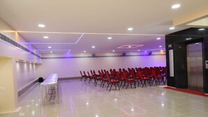 A conference room with rows of chairs, a table, and an elevator. - Shri Valli Resdiency (Chennai)
