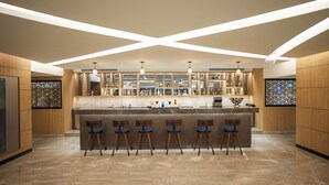 A modern bar area with a marble countertop, bar stools, and a variety of bottles and glasses. - Transit by Encalm - Nap and Shower (Hyderabad)