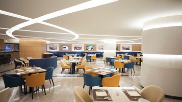 A modern restaurant with multiple dining areas, a bar, and a TV screen displaying content.