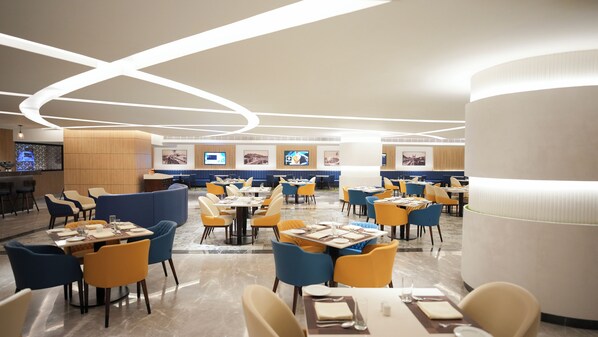 A modern restaurant with multiple dining areas, a bar, and a TV screen displaying content. - Transit by Encalm - Nap and Shower (Hyderabad)