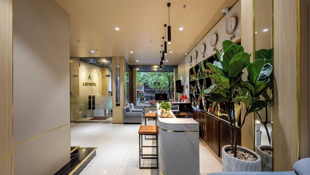 A modern hotel lobby with a reception desk, seating area, and a view of the outside. - A25 Premium Hotel - 277 Le Thanh Ton (Ho Chi Minh City)