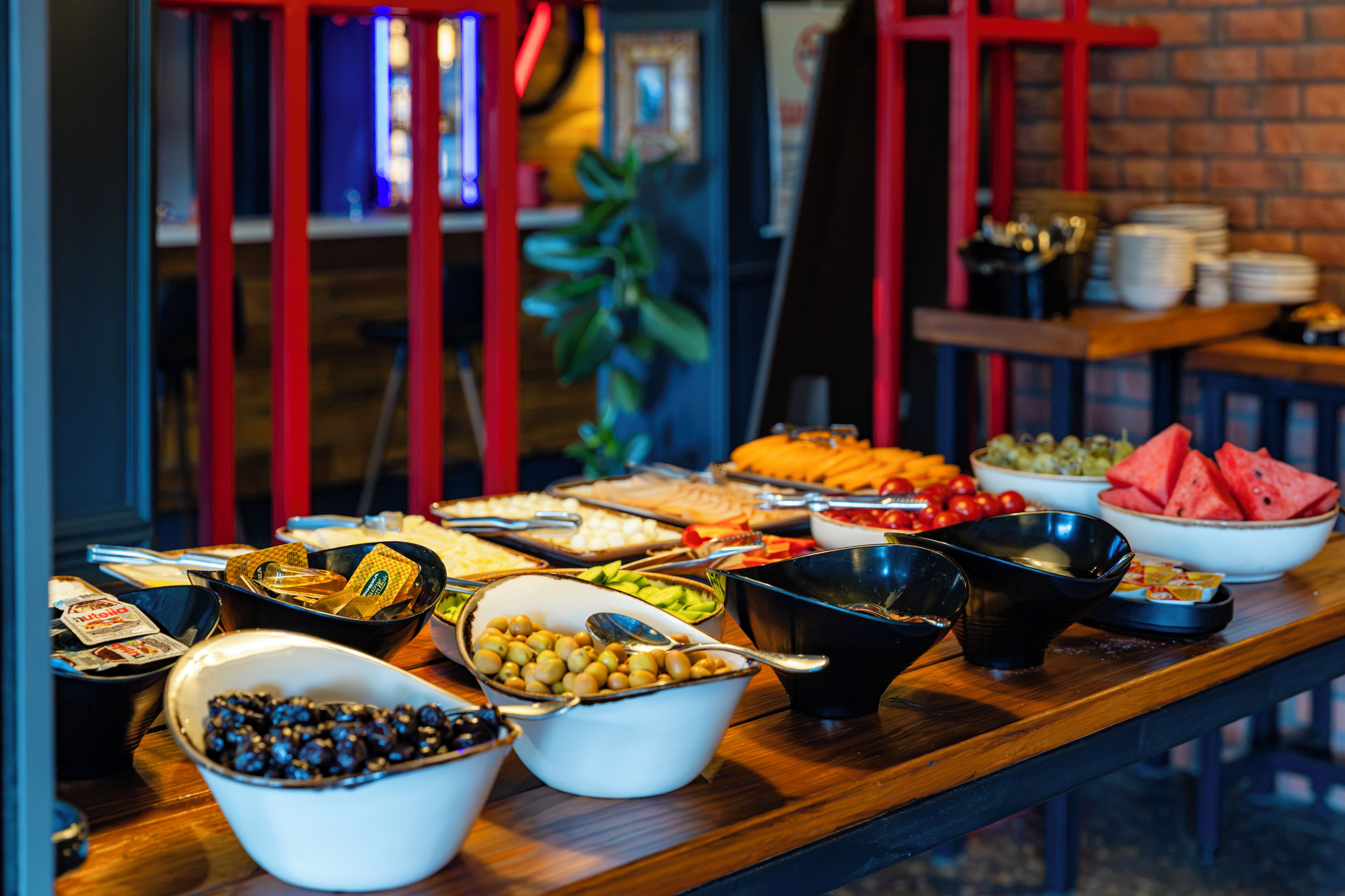 Una mesa de bufé con diversos alimentos y utensilios.