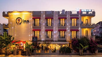 Un hotel con un letrero grande que dice '7in', varios balcones y un letrero que indica 'Gastro & Pub', con opciones de comida y entretenimiento.