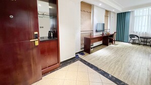 A hotel room with a wooden wardrobe, a desk with a television, a chair, and a large window with curtains. - Yundu Business Hotel (Xianyang)