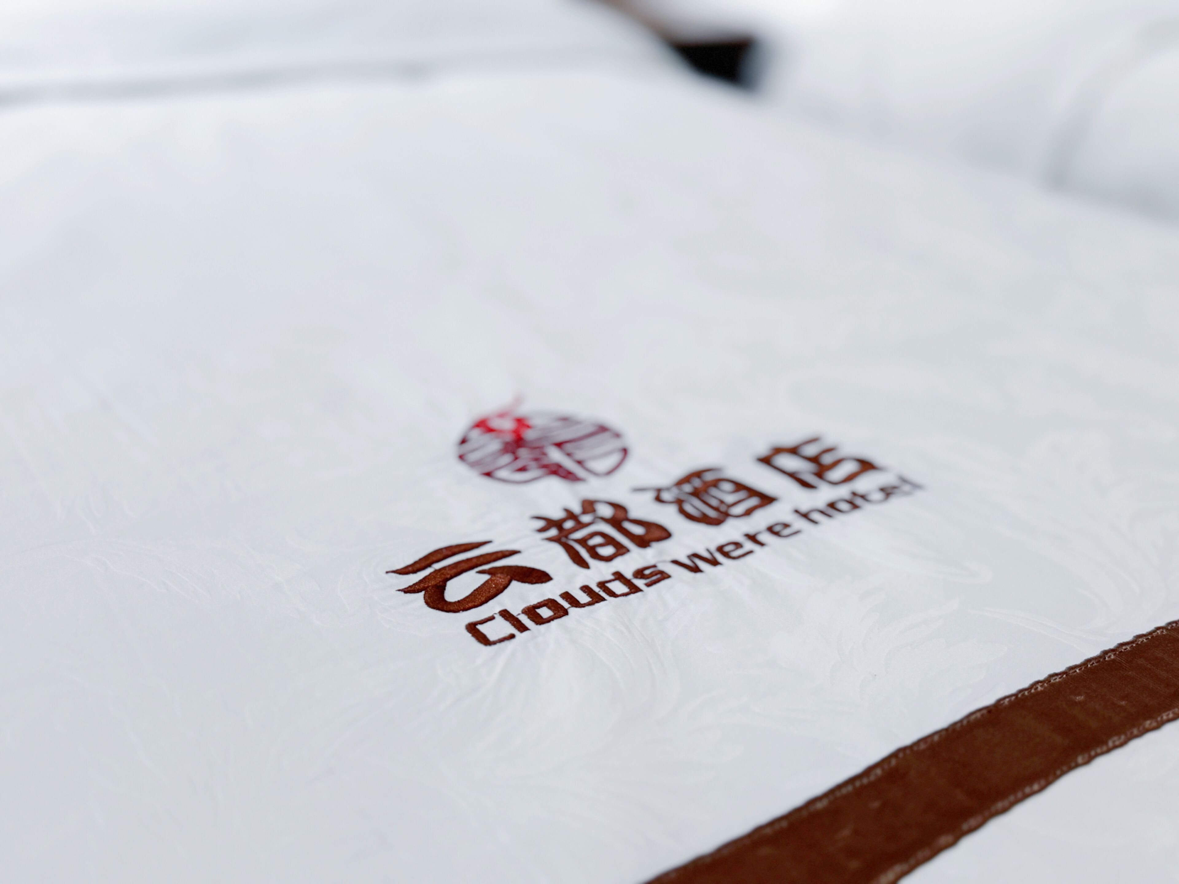 A white hotel room with a logo and text on the wall.