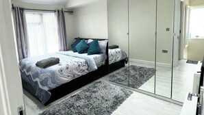Une chambre à coucher moderne avec un lit, un miroir et une armoire.