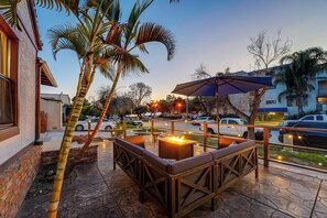 An outdoor patio with a fire pit, seating, and palm trees. - Dream Location! Fire Pit, Fenced Yard, Steps To Bay! (San Diego)