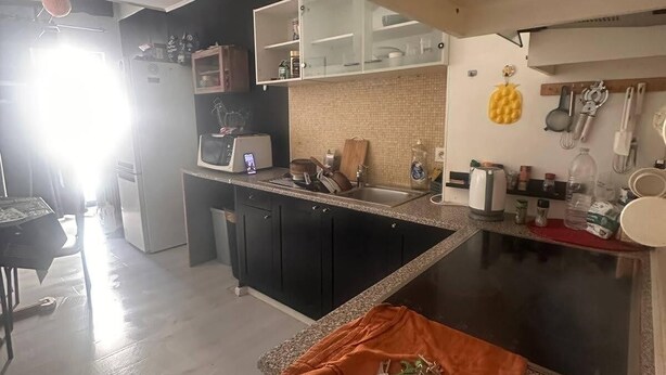 A modern kitchen with a central island, built-in appliances, and a dining area with a chair. - TML Tomorrowland safe space with 24/7 taxi included (Mechelen)