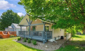 A two-story house with a covered porch and a small deck.