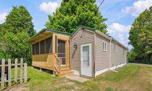 A small, single-story house with a screened porch and a garage.