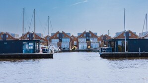 A marina with multiple houses and boats docked. - Luxury Houseboat Getaway (Uitgeest)