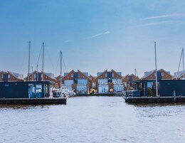 A marina with multiple houses and boats docked.