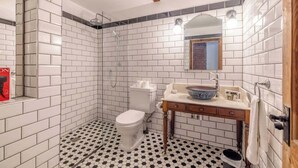 A bathroom with white subway tiles, a black and white checkered floor, a toilet, a sink with a mirror, and a shower. - Cosy 2-Bed Cottage, close to Windsor By Tempstay (Berkshire)