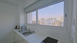 Una piccola cucina con finestra, lavandino e un tostapane.