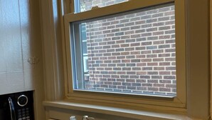 Ein Badezimmer mit Fenster, Waschbecken und Mikrowelle.