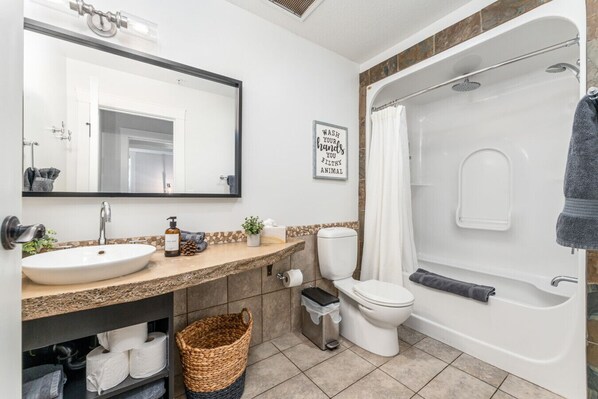 A modern bathroom with a sink, toilet, and bathtub.