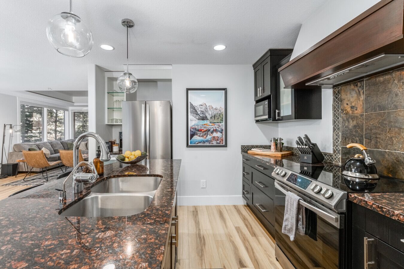 A modern kitchen with granite countertops, stainless steel appliances, and a large island.