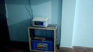 A small wooden table with a computer and a blue box on it. - Madhu Vatika Homestay By GRB (Patna)