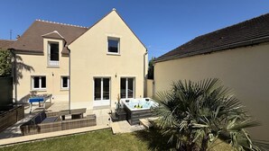 Une maison à deux étages dotée d’un patio, d’un jacuzzi et d’une table de baby-foot.