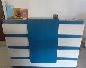 A reception desk with a blue and white color scheme, featuring a central blue panel and white drawers. - Dremzzz Vivo Jogja (Depok)