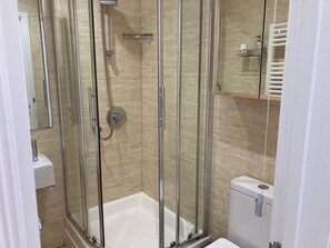 A modern bathroom with a glass-enclosed shower, a white bathtub, and a toilet. - Flat 4, 10 Porthminster Terr Sleeps 4, 2 bedrooms, 2 bathrooms, WiFi and parking (St Ives)
