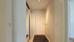 A narrow hallway with a carpeted floor leading to a door. - Forenom Serviced Apartments Espoo Nupuri (Espoo)