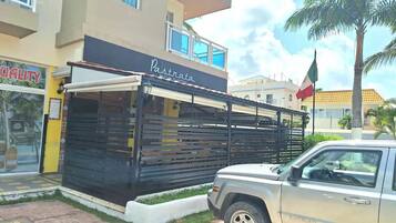 Un edificio con un letrero que dice 'Pastrata Mexican Restaurant' y un SUV estacionado.