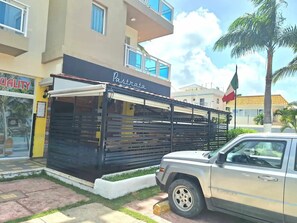 A building with a sign for 'Pastrata Mexican Restaurant' and a parked SUV.