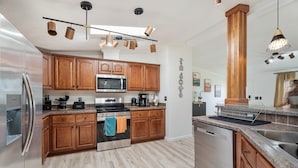 Una cocina moderna con armarios de madera, electrodomésticos de acero inoxidable y encimera de granito.
