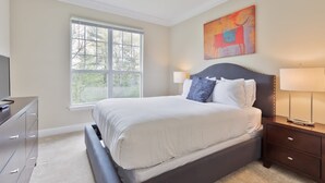 Une chambre à coucher avec un lit, une fenêtre, un tableau, une télévision et une commode.