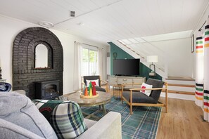 Una sala de estar acogedora con chimenea, televisión y un espacio de descanso cómodo.