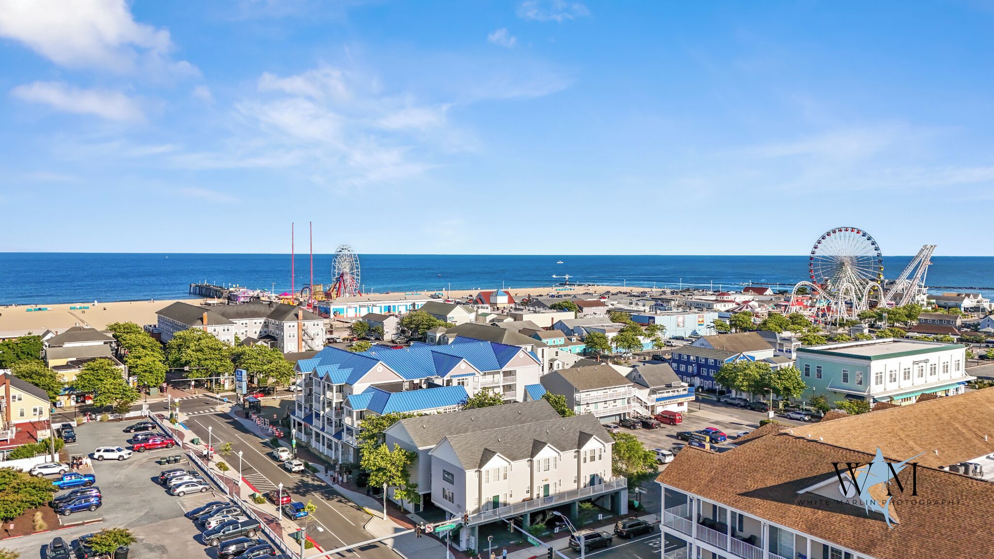 Une ville côtière dotée d’une plage, d’une grande roue et de différents bâtiments.