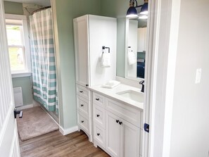 Een haardroger, handdoeken, zeep, toiletpapier