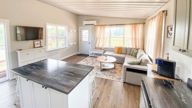 Un amplio salón con sofá, mesa de centro y encimera de cocina.