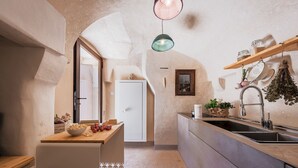 Eine Küche mit einer Holztheke, einem weißen Kühlschrank und einem Spülbecken mit einer hängenden Pflanze.