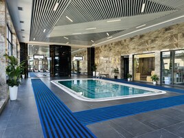 Una piscina techada, una piscina al aire libre de temporada, sombrillas