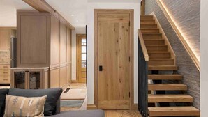 A modern interior with a wooden staircase, built-in cabinets, and a cozy seating area. - Vail Village Luxury 4 Bedroom, Steps to Slopes! (Vail)