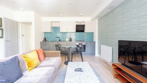 Ein modernes Wohnzimmer mit einer Couch, einem Couchtisch und einem Essbereich mit Stühlen.