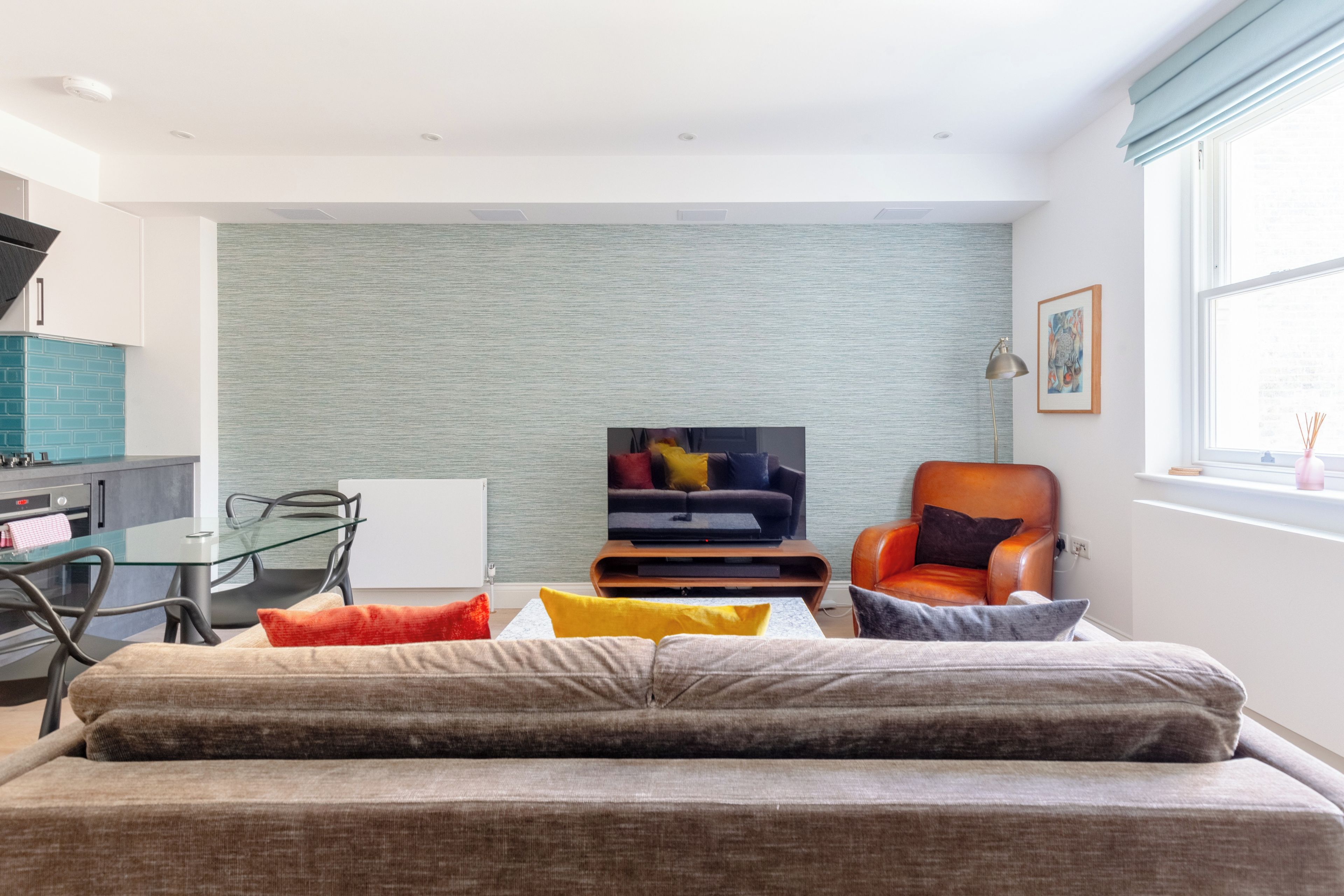 A modern living room with a sofa, a coffee table, and a television.